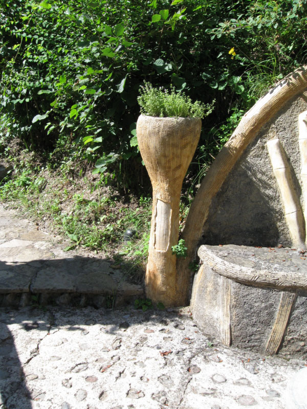 Testo
Abans d'arribar als forns, a mà dreta hi ha una plaça rodona amb un banc i unes taules de pedra amb dos testos a cada costat.
